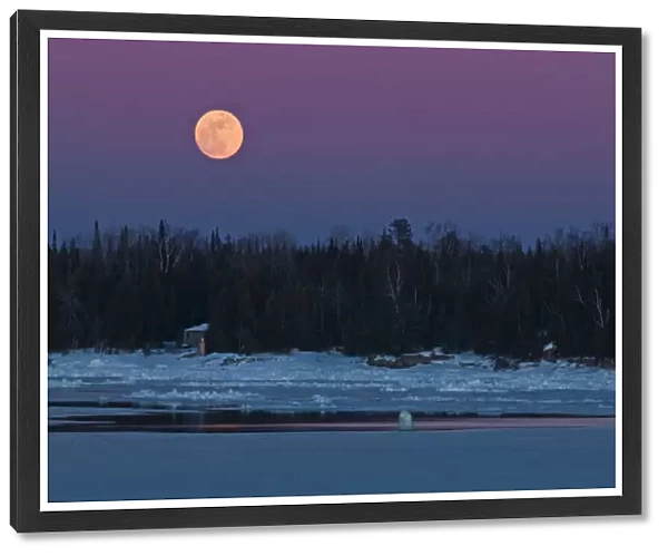 Canada, Ontario, South Baymouth. Full moon rising over Lake Huron in winter. Credit as