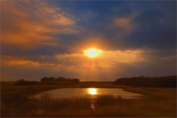 Canada, Saskatchewan, Dubuc. Sunset over pond