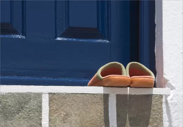 Europe, Greece, Mykonos, Hora. Orange slippers on threshold of blue door. Credit as