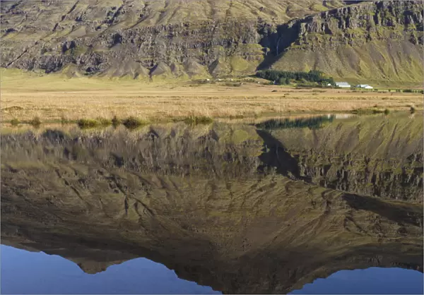 Mountain and homestead reflection in Lake, Iceland
