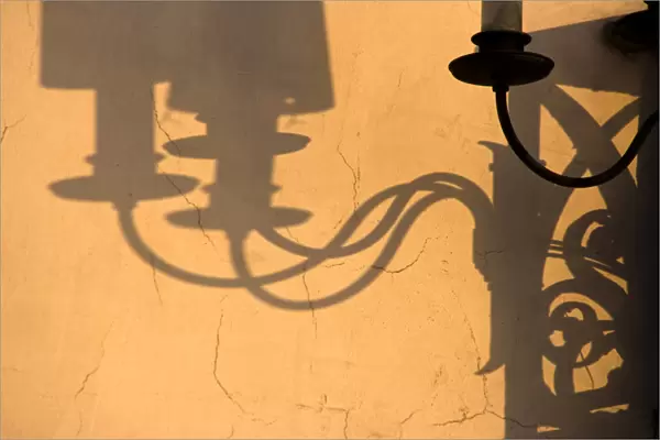 Europe, Italy, Venice. Lamp and shadows on a yellow wall