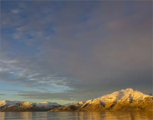 Greenland. Kong Oscar Fjord. Sunset light on the snowy mountains