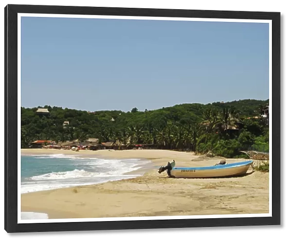 Mexico, Mazunte, view of a nautical vessel moored on sand at the shore of the beach with trees
