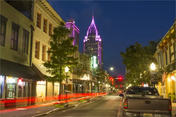 Mobile Alabama downtown traffic on Dauphin Street at twilight with Trustmark Skyscrapper