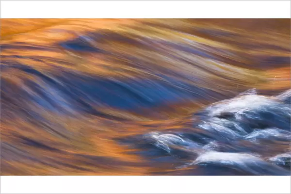 Painterly Impression of a rushing stream reflecting autumn colors