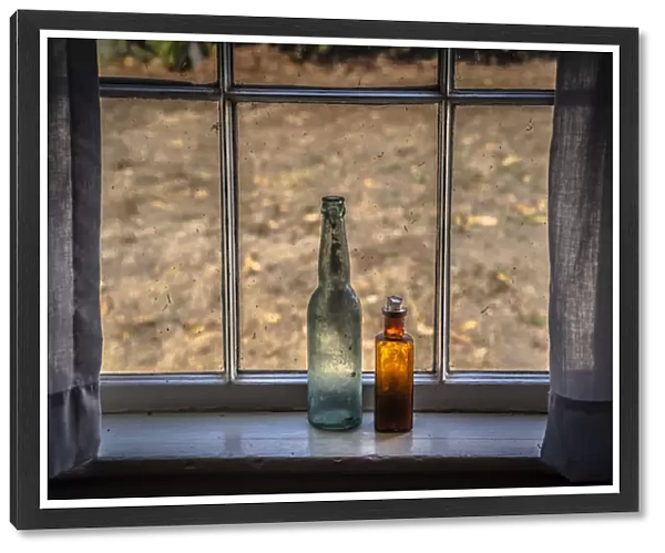 Two vintage bottles on window sill