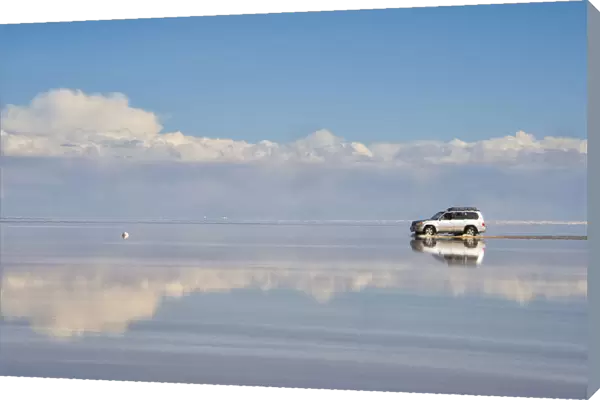 Jeep driving on the reflected surface of the salt flat, Salar de Uyuni, Potosi Department