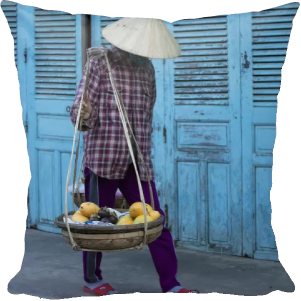 Vietnam. Street vendor with fruit and vegetable basket. Hoi Anh