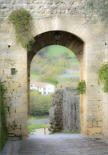 Italy, Chianti, Monteriggioni. Looking out an arched entrance into the walled town