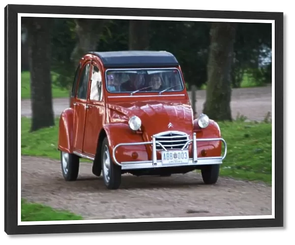 An old red Citroen 2CV car with a smiling woman driving, Elisa Trabal de Bouza owner