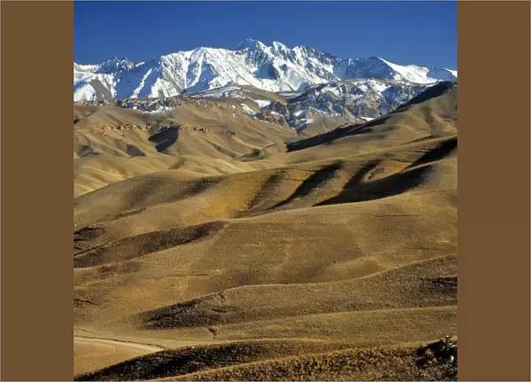 Afghanistan, Bamian Valley. Rolling hills lead to the snow fields of the rugged Hindu