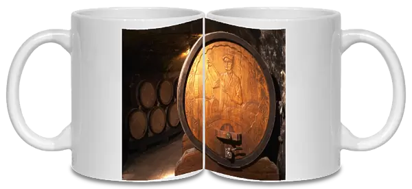 Wooden storage vat with aging wine of Guigal in Ampuis. The end of the vat is carved