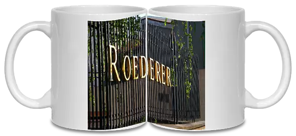 Wrought iron fence with golden letters shining in the setting sun at Champagne Louis Roederer