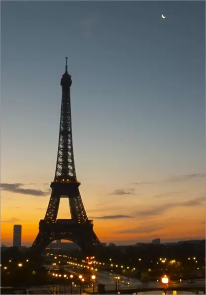 The Eiffel Tower in Paris in early morning, pale blue sky some white clouds and the