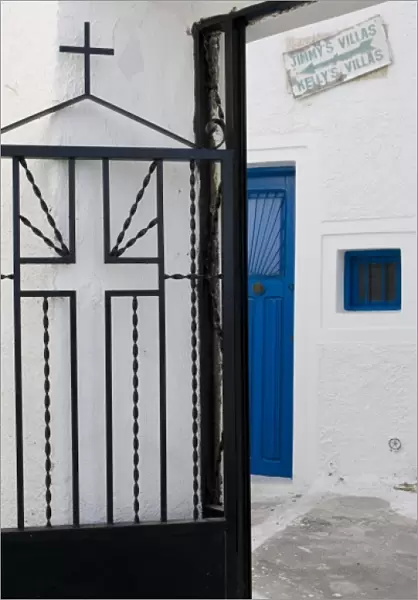 Greece, Santorini. Black iron church gate against white wall