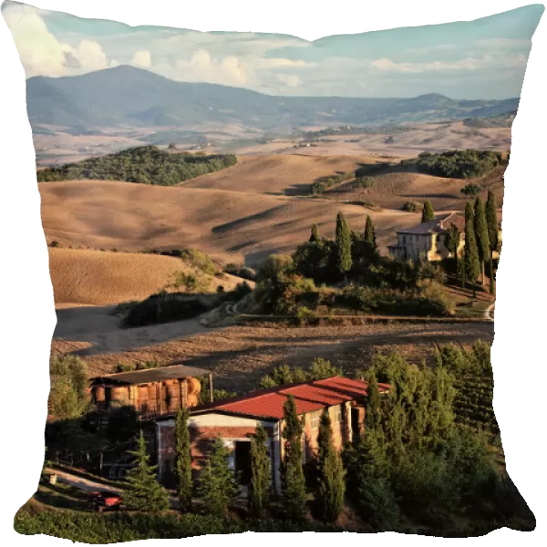 Sunset light on rolling agricultural hills of Tuscany after the harvest, San Quirico