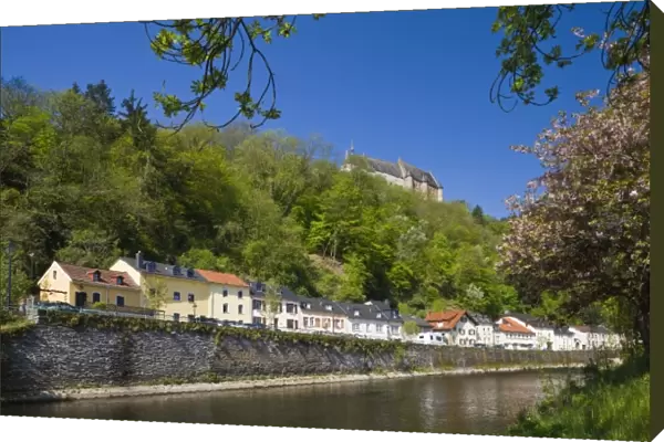 Luxembourg, Vianden. Town buildings and Vianden castle along Our River, morning