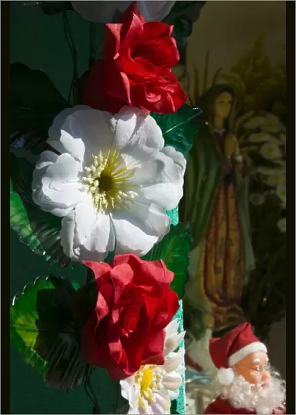 Mexico, Guerrero, Barra de Potosi. Flowers and Virgin of Guadalupe statue