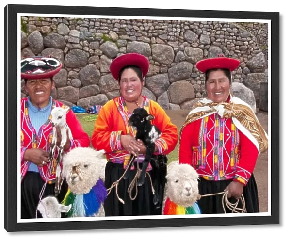 Traditional women with colorful clothes and llamas in religious region Saqsayhuaman