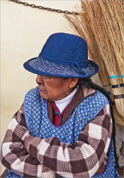 Traditional woman in costume selling brooms in Cuzco Cusco Peru (MR)