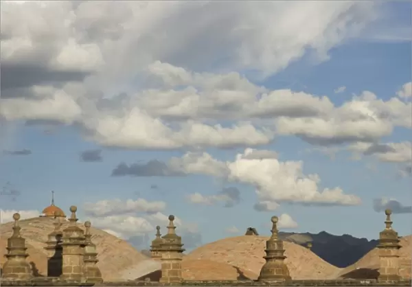 Stone roofs under puffy clouds, Cuzco, Peru