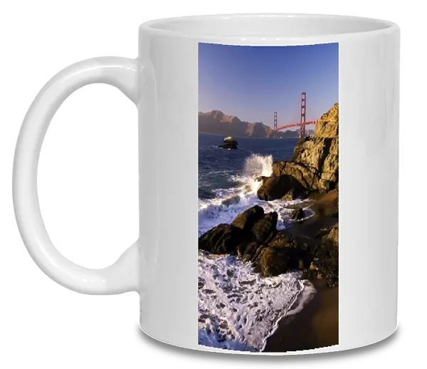 Waves crash on the California coast overlooking the Golden Gate Bridge