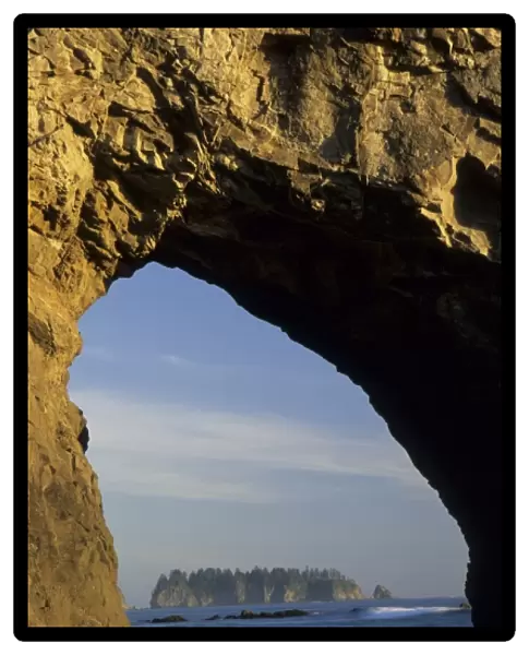 Island viewed through arch in sea stack, Rialto Beach, Olympic National Park, Washington
