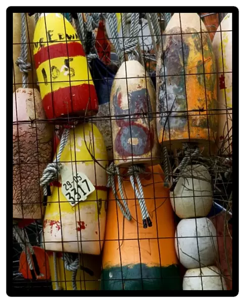 Stock photo of bouys hung on a fence at a shipyard