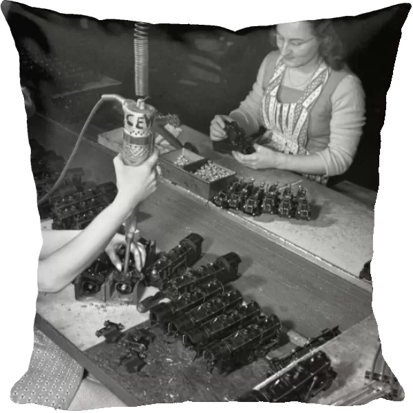 Factory workers Stephanie Cewe (left) and Ann Manemeit at work at a toy factory in New Haven, Connecticut. Stephanie assembles toy trains while Ann attaches the trains to their chassis. The factory was later converted to manufacture parachute flare casings during World War II. Photograph by Howard R. Hollem, 1942