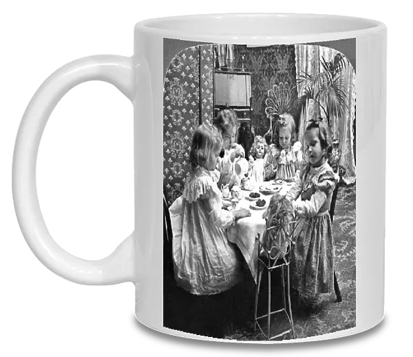 Four girls and their dolls sitting around a table and having a tea party. Stereograph, c1902