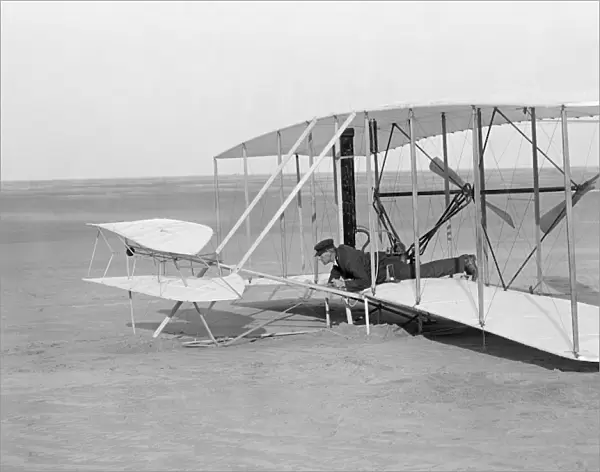 Wilbur Wright in prone position in damaged glider after unsuccessful trial, Kitty Hawk, North Carolina. Photographed by Orville Wright on 14 December 1903