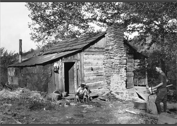 HINE: LOG CABIN, 1921. A small run-down log cabin occupied by a family that has