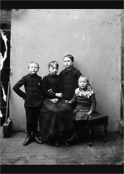 MIDDLE CLASS CHILDREN, 1900. Four siblings photographed in an American photographs studio
