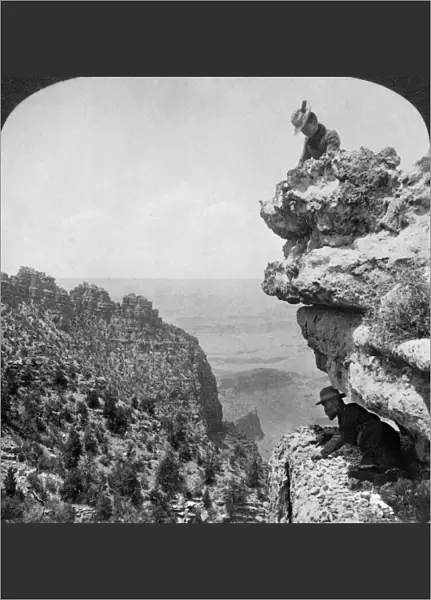 GRAND CANYON: SIGHTSEERS. A woman and a man on a cliff overlooking the Grand Canyon in Arizona