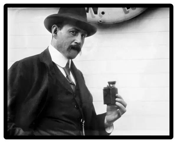 PHOTOGRAPHY: CAMERA. A German scientist holding a detective camera. Photograph, c1912
