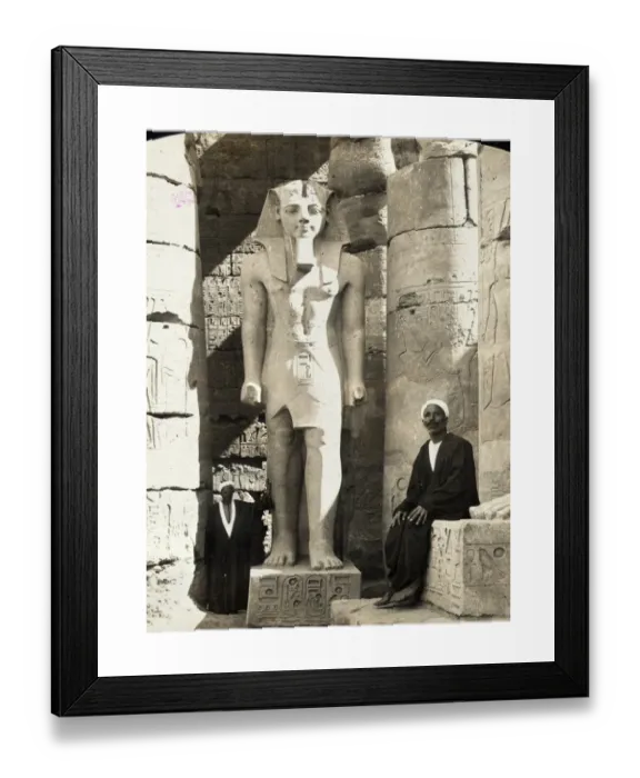 Framed Print : Print of a man seated next to a statue of Ramesses II at Luxor Temple Framed Print : Print of a man seated next to a statue of Ramesses II at Luxor Temple