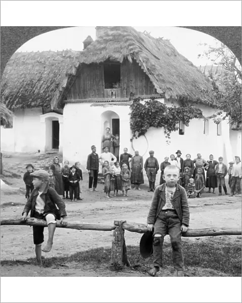 CZECH VILLAGE, c1893. Two boys sitting on a rail fence in front of a building with