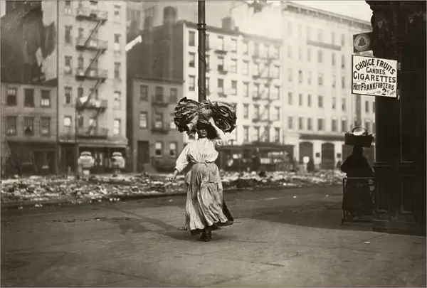 HINE: HOME INDUSTRY, 1912. An Italian immigrant woman carrying a heavy bundle of