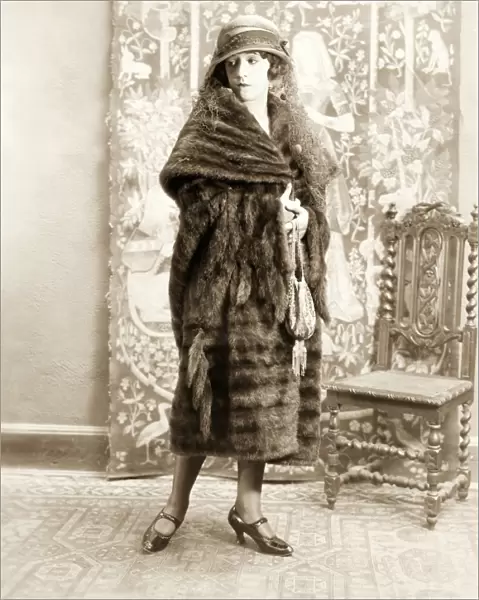FASHION: FUR, 1925. American actress Helen Ferguson wearing a mink dolman trimmed with tails