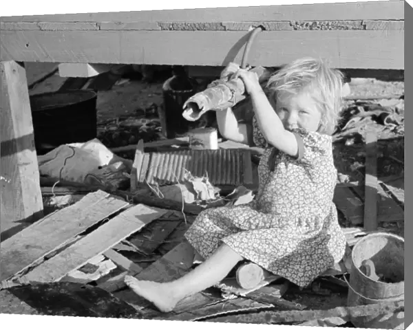 MIGRANT CHILD, 1939. Daughter of a migrant family clutching trailer connections