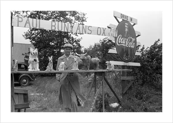 ROADSIDE STAND, 1939. A man selling animal statues at a roadside stand near Bemidji, Minnesota