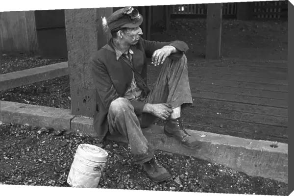 COAL MINER, 1935. A coal miner taking a break from working at the Consolidated Coal Company