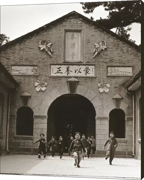 CHINA: SCHOOL CHILDREN. Smiling young school children running out of the entrance