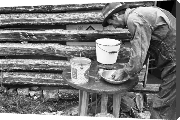 ARKANSAS: SHARECROPPER. A sharecropper washing his hands in a small water basin
