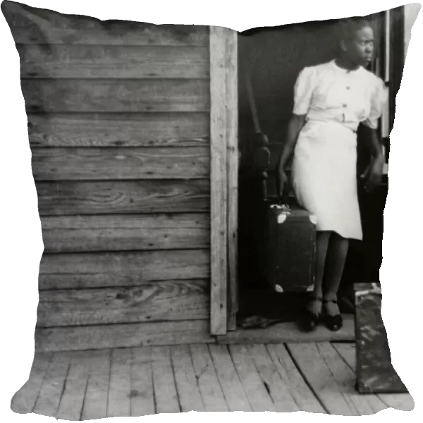 MIGRANT WORKER, 1940. A Florida migrant worker bringing her luggage outside in