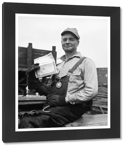 WWII: HOMEFRONT, 1943. A worker holding a war bond at the Bethlehem-Fairfield Shipyard