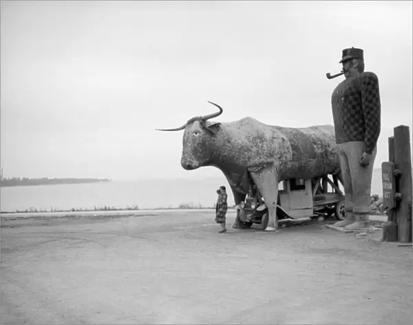 PAUL BUNYAN MONUMENT, 1939. Woman standing in front of the Paul Bunyan Monument in Bemidji