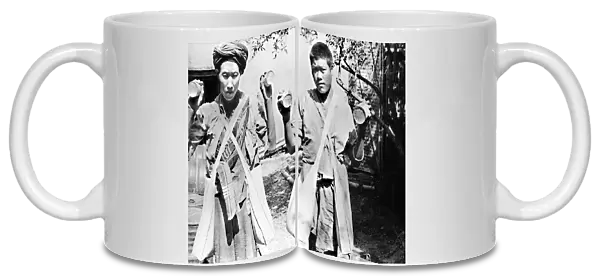 CHINA: CHEFANG, c1940. Two Chinese workers holding up cans with holes punched in