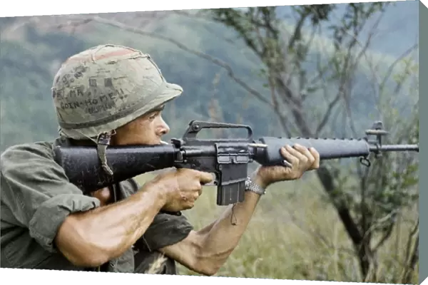 VIETNAM WAR, 1967. Private Michael Mendoza firing a M-16 rifle in the direction of sniper fire
