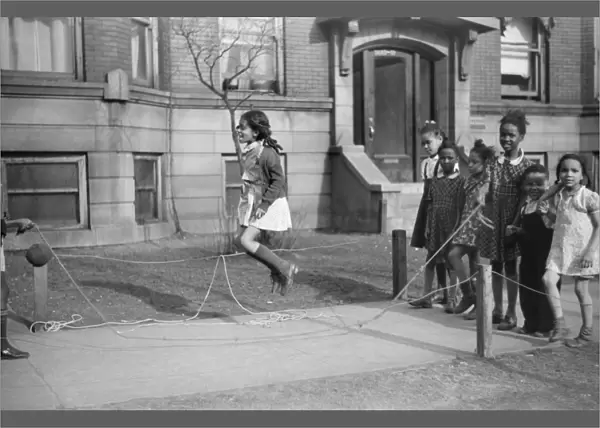 CHICAGO: CHILDREN, 1941. Children jumping rope outside of an apartment building